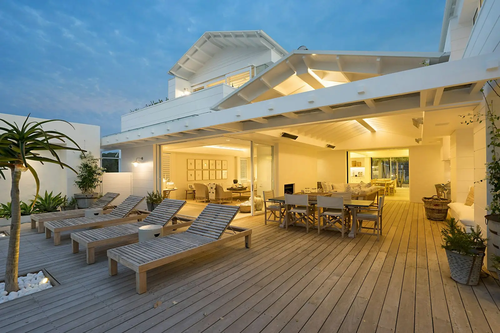 Terrasse en bois d’une maison contemporaine éclairée en soirée